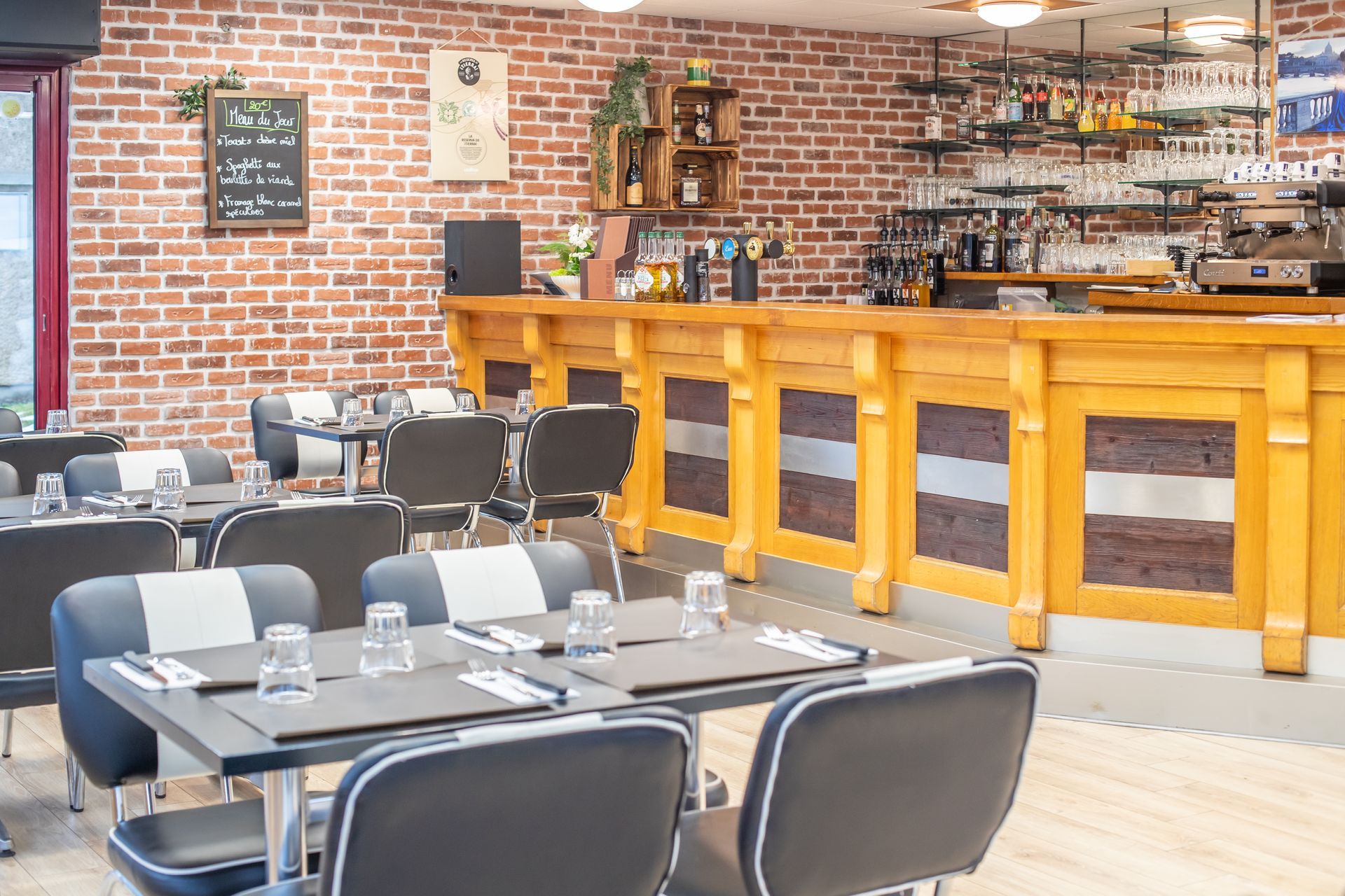 Intérieur d'un restaurant avec vue sur les montagnes enneigées. Tables et chaises au premier plan.