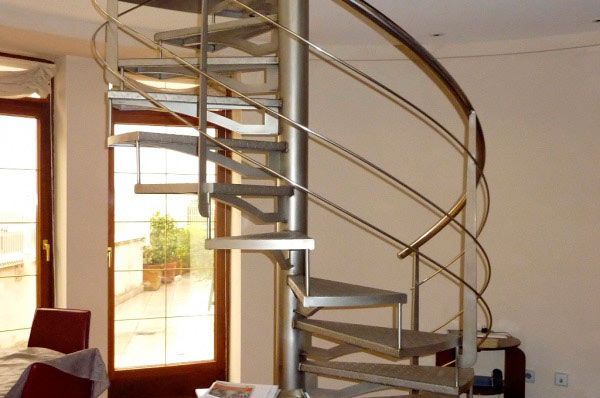 Una escalera de caracol en una sala de estar con una ventana.