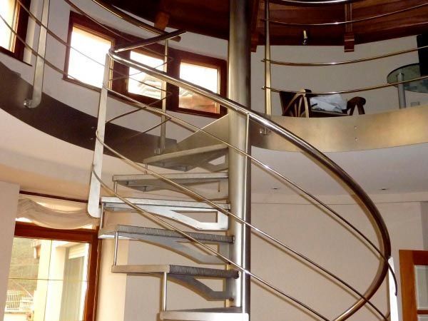 Una escalera de caracol con barandilla de acero inoxidable