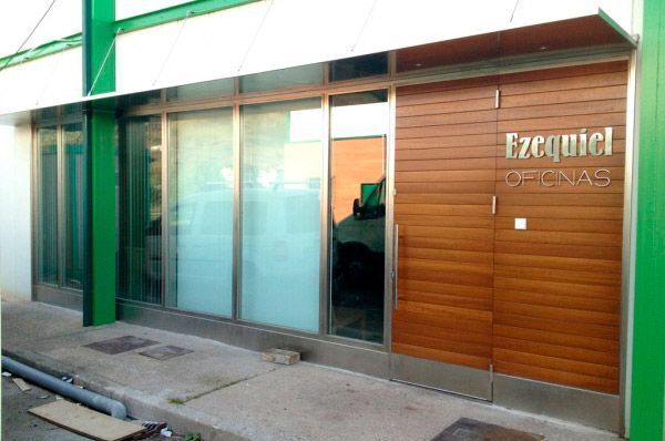 Un edificio con una puerta de madera y un cartel que dice ezequiel oficinas