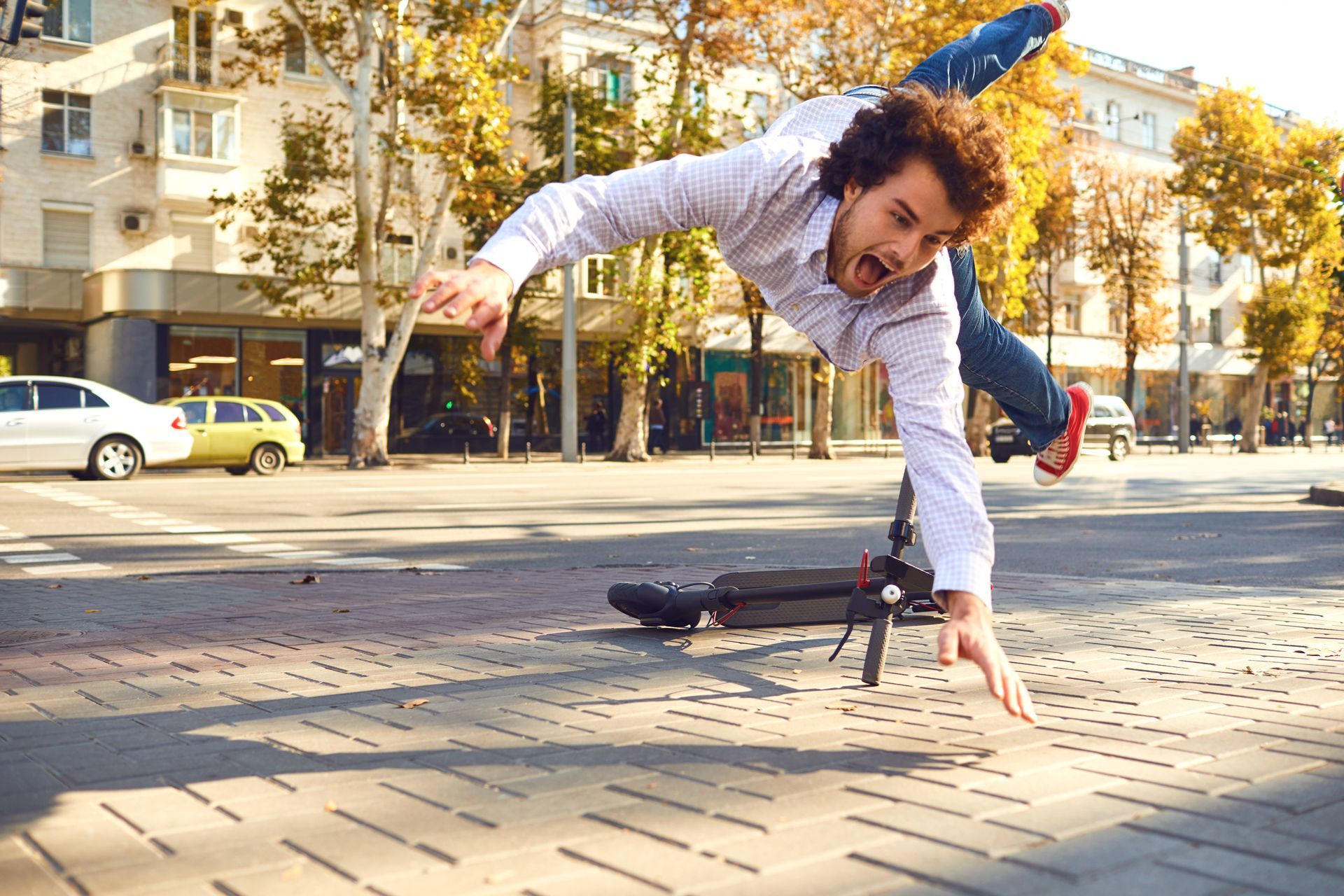 Homme tombant de sa trotinette électrique