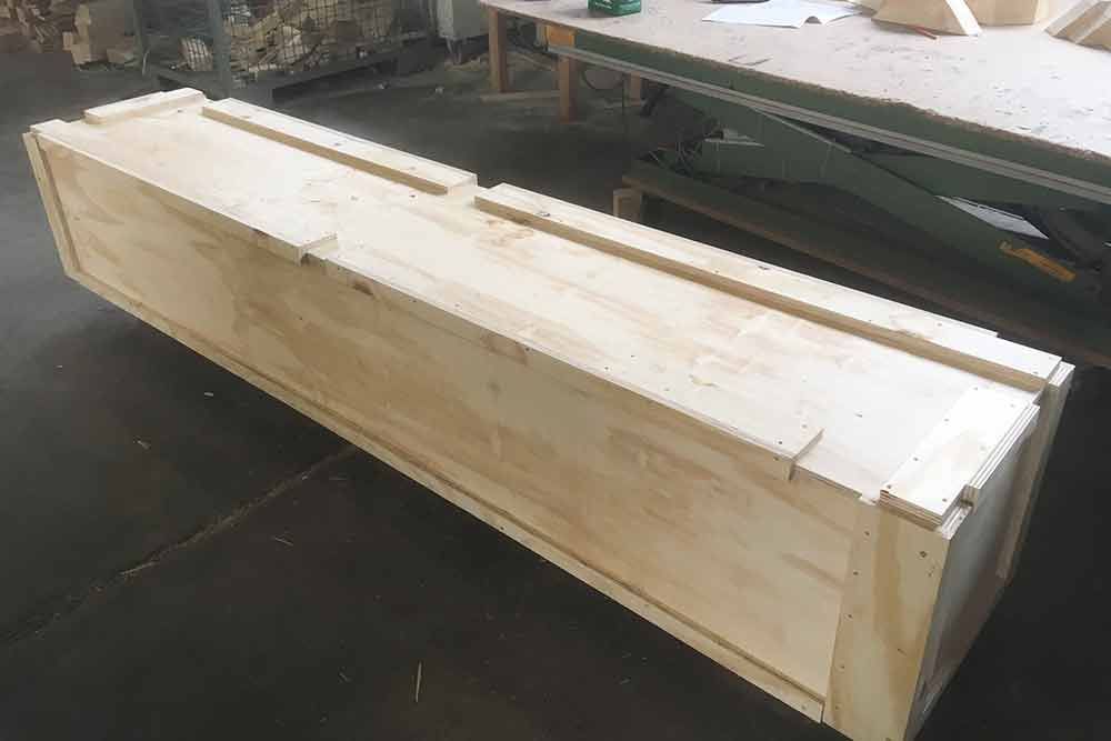 Auf einem Holztisch steht eine lange Holzkiste.