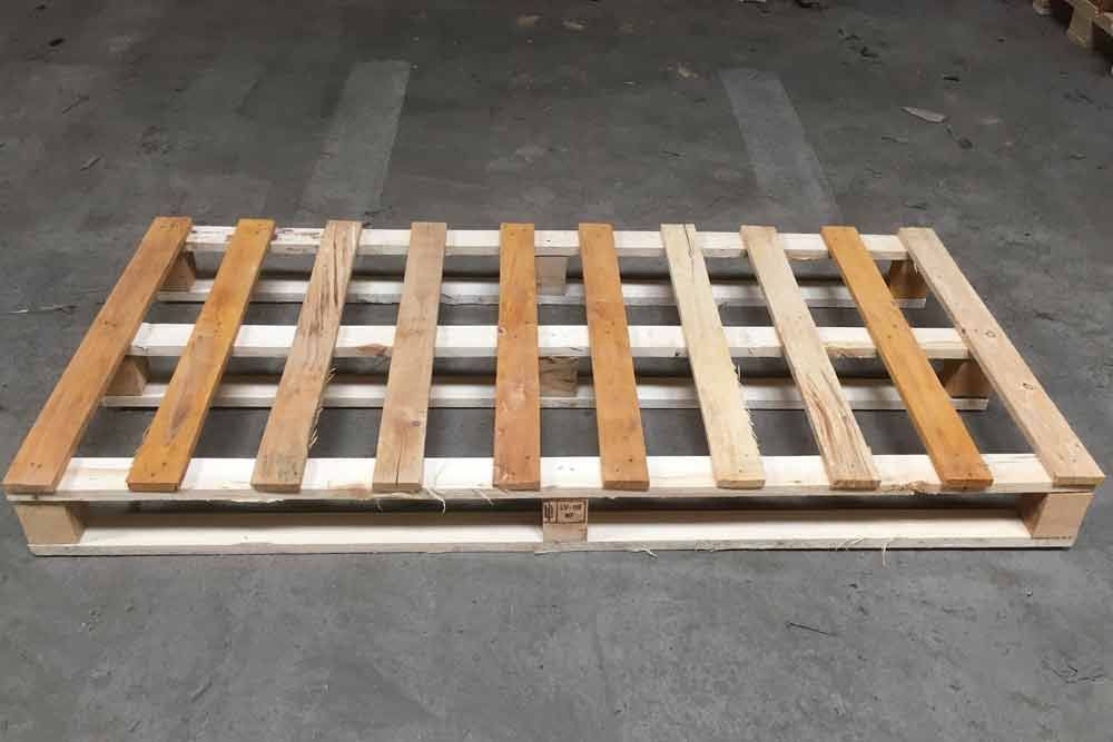 Auf einem Parkplatz steht eine Holzpalette auf dem Boden.