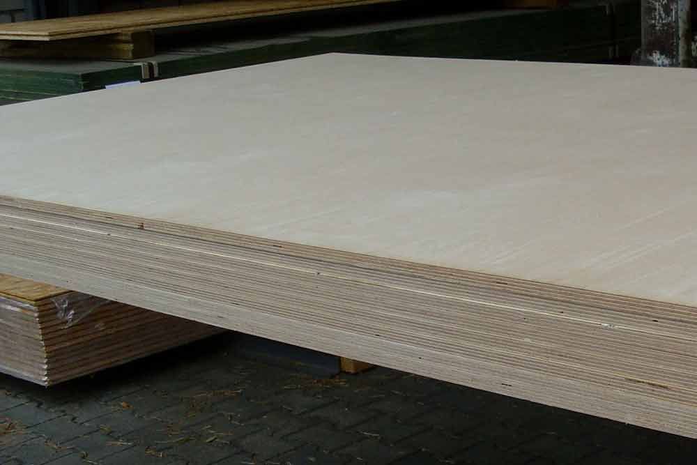 Auf einer Holzpalette liegt ein großes Stück Sperrholz.