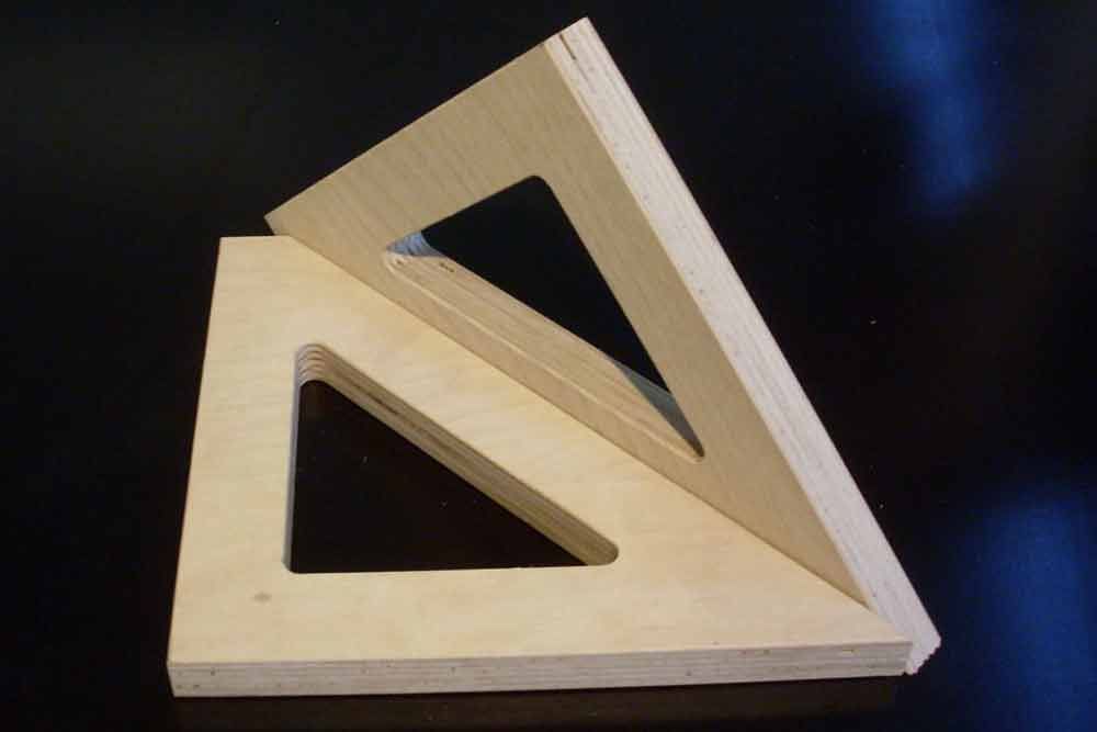 Zwei hölzerne Dreiecke sind übereinander auf einem Tisch gestapelt