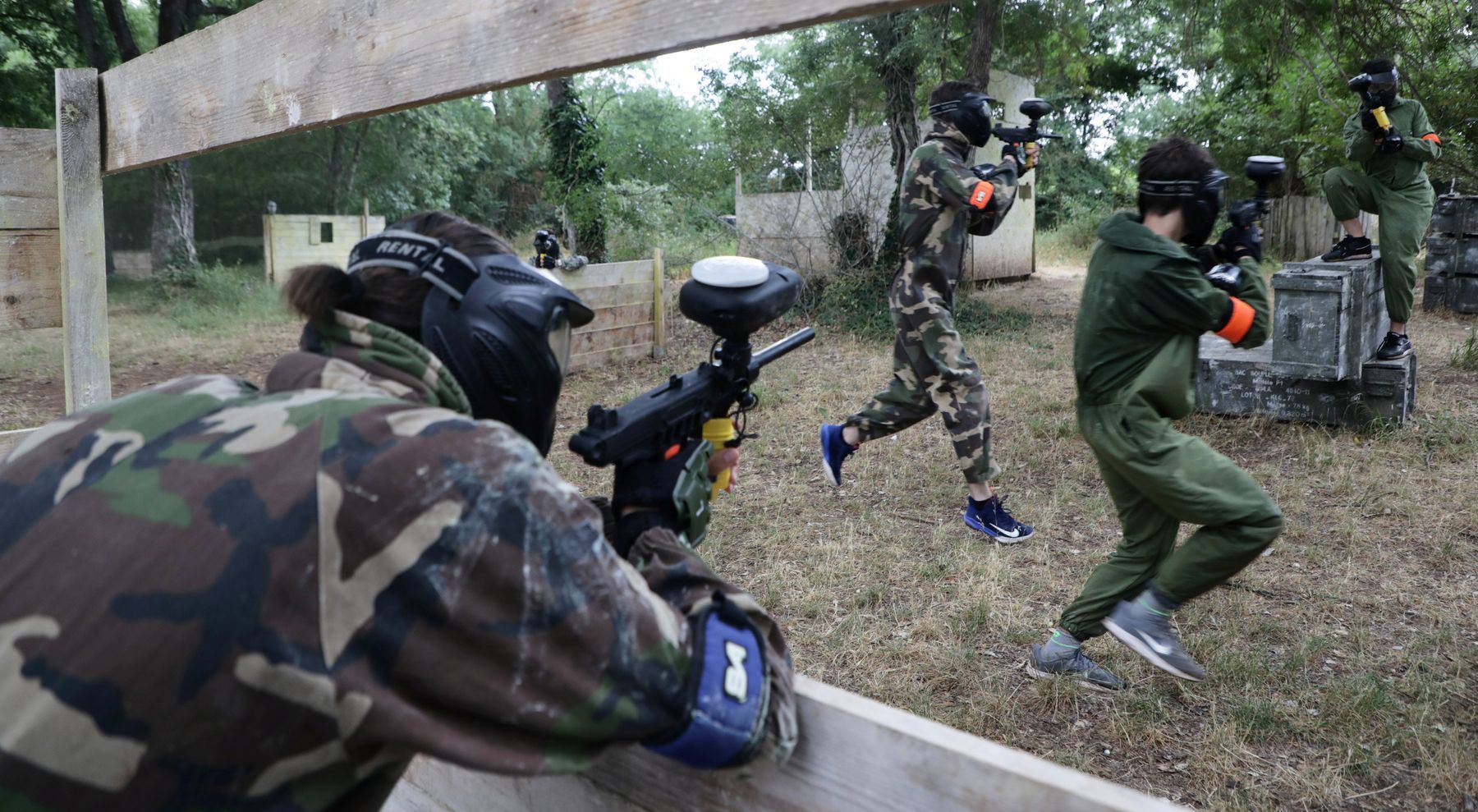 Trois personnes faisant du paintball