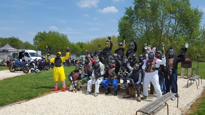 Plusieurs personnes lèvent les mains sur un terrain de paintball