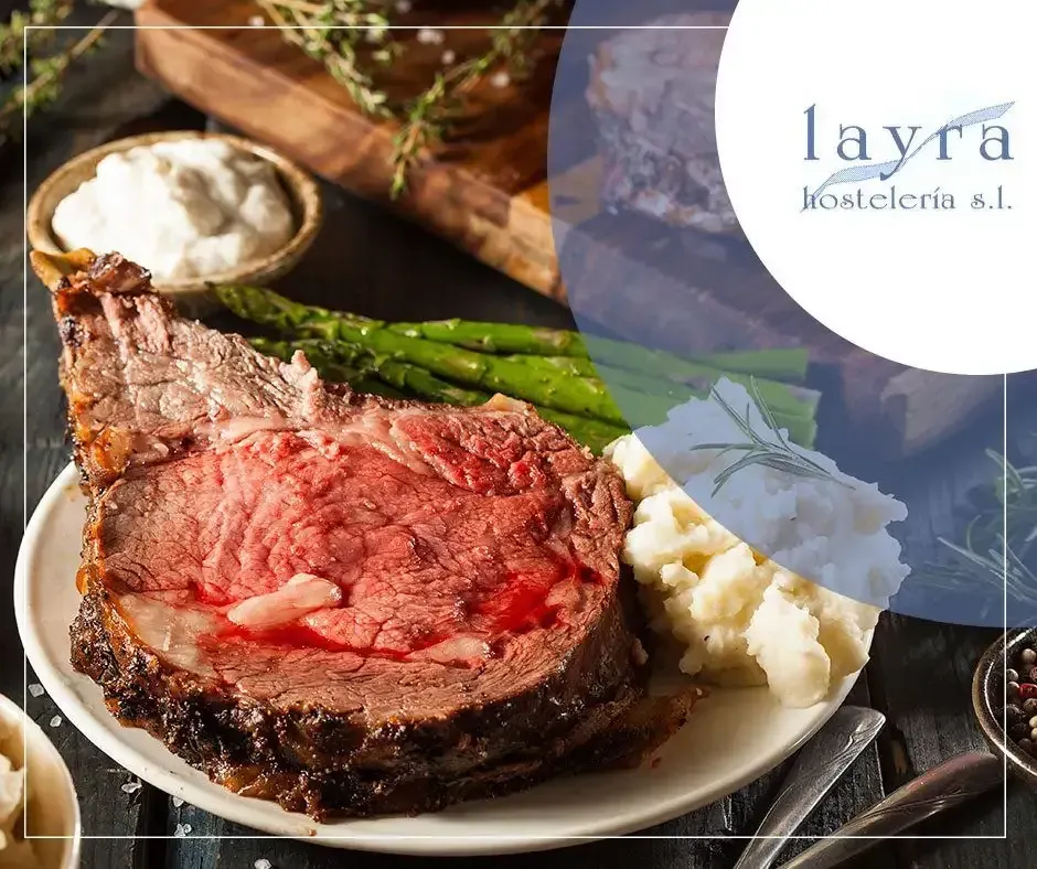 Una rebanada de carne asada en un plato con puré de patatas y espárragos.