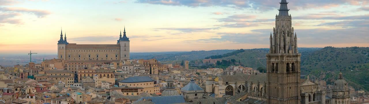 Una vista aérea de una ciudad con una catedral en primer plano y un castillo al fondo.