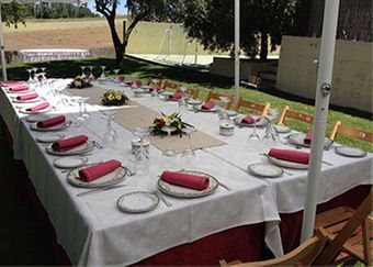 Una mesa larga con platos y vasos encima.