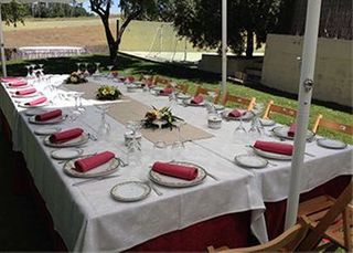 Una mesa larga con platos y vasos encima.