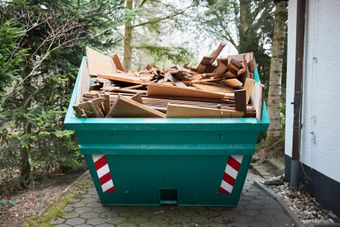 Benne verte avec déchets bois et carton