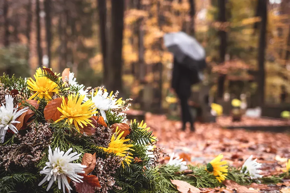 Waldbild mit Blumen und einer Frau im Hintergrund