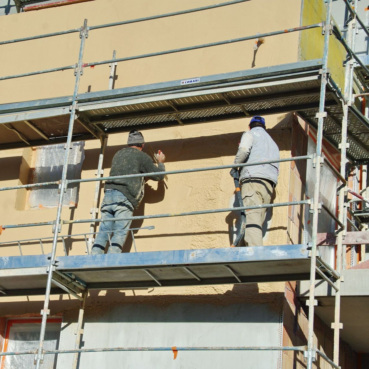 Deux ouvriers qui réalisent un ravalement de façade