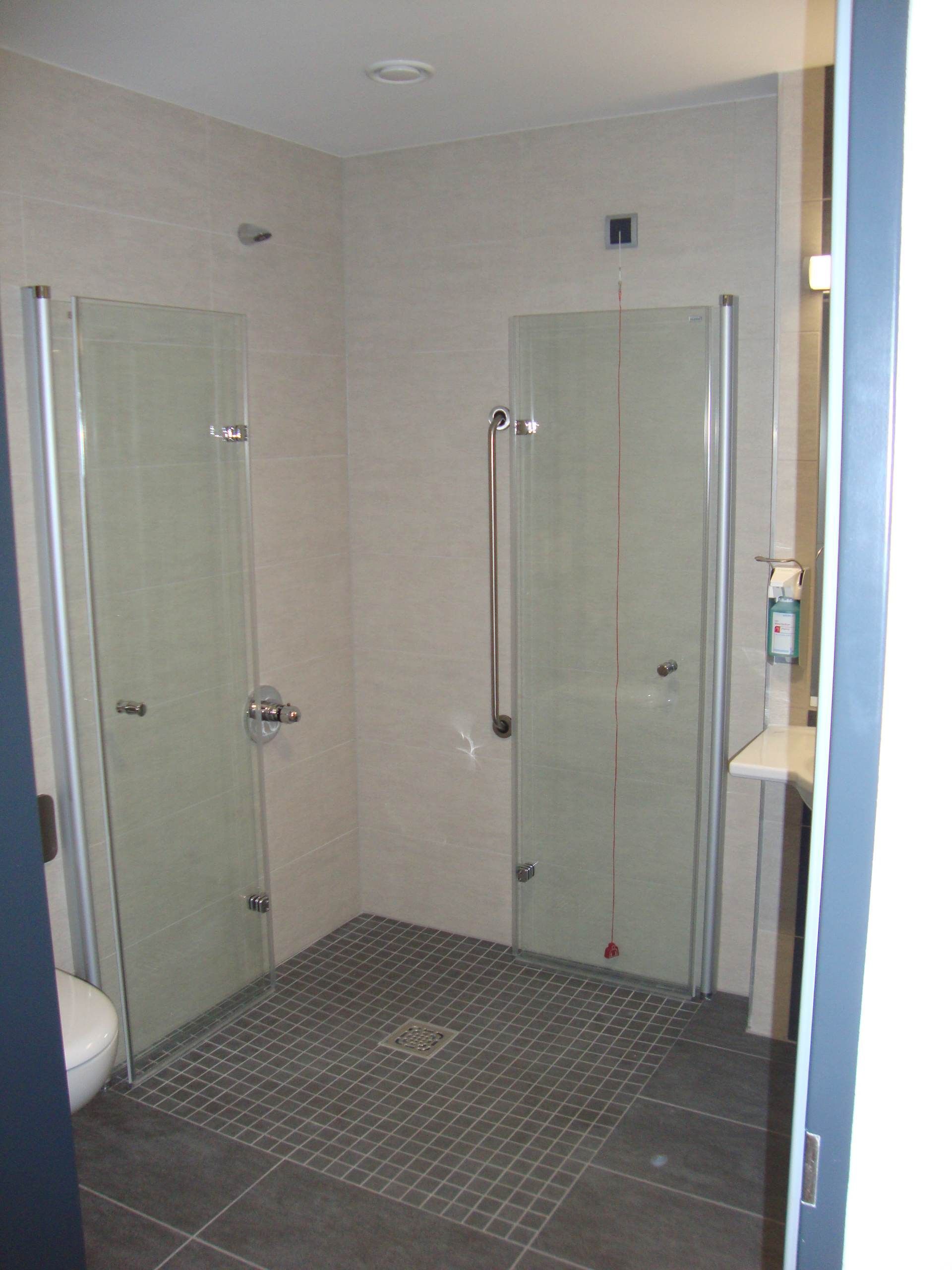 Dusche mit Glastür und Fliesenboden