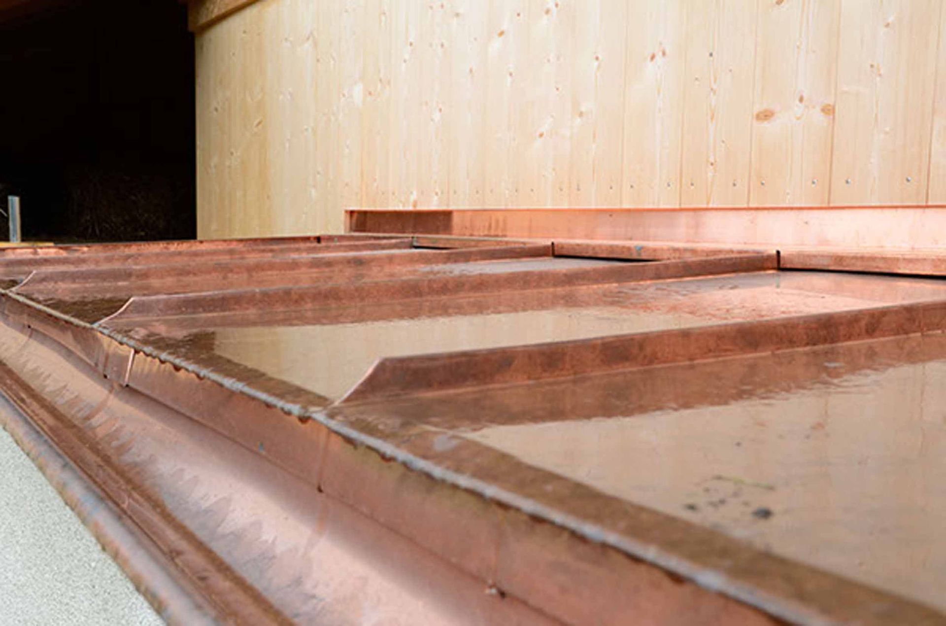 Doppelfalzdach in Kupferblech mit vorgehängter Rinne – Klopfenstein Spenglerei