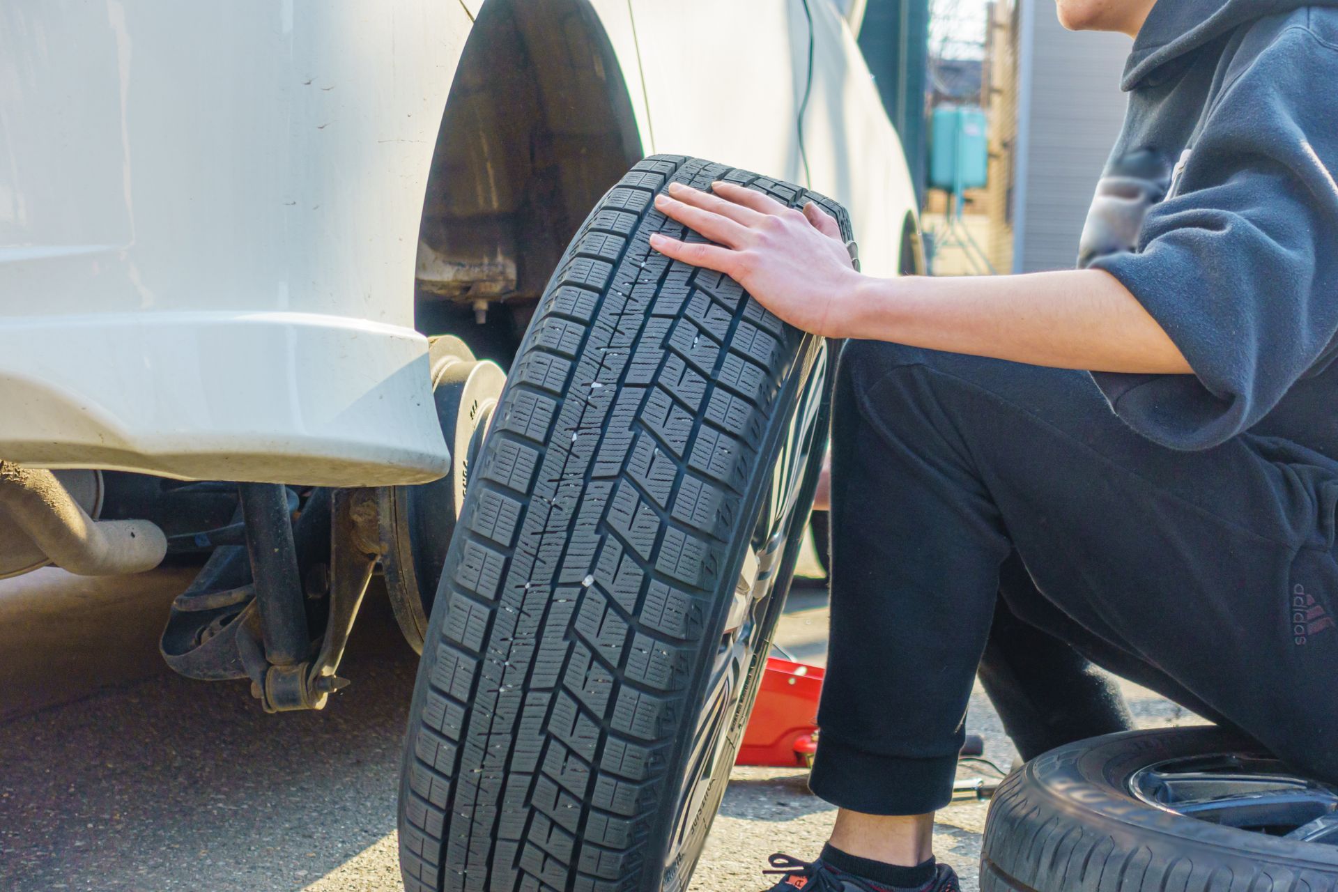 Personne changeant un pneu de voiture.