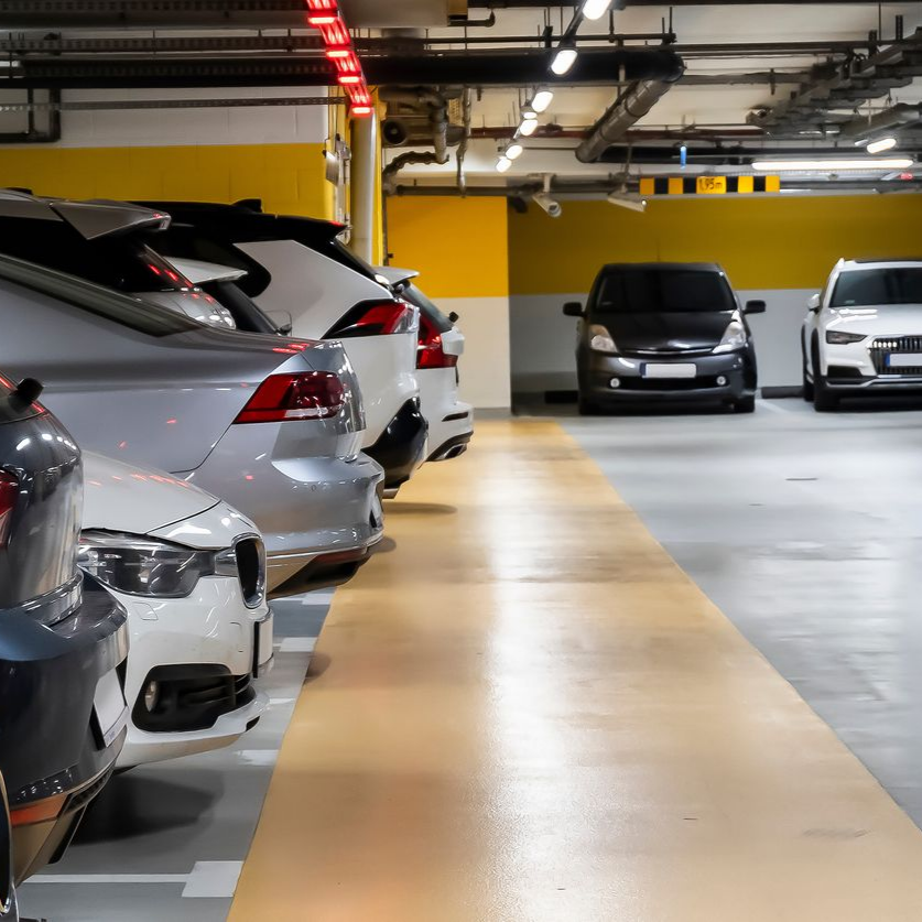 Série de voitures dans un parking souterrain jaune et gris