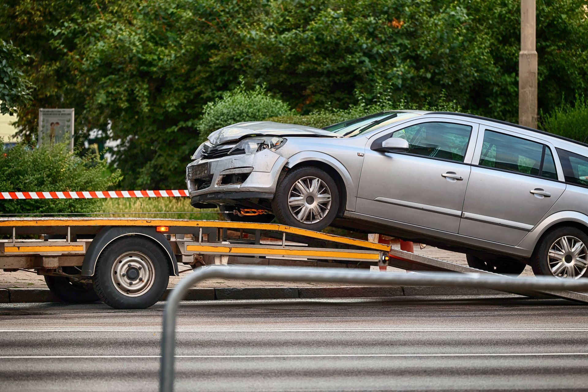 Une voiture, l'avant endommagé, est remorquée sur une remorque à plateau.