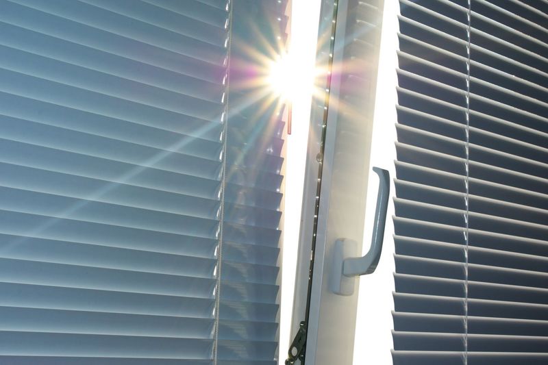 Fenster mit Sichtschutz, welches auf Kipp ist. Sonne scheint durch. Fenster mit Sichtschutz, welches auf Kipp ist. Sonne scheint durch.