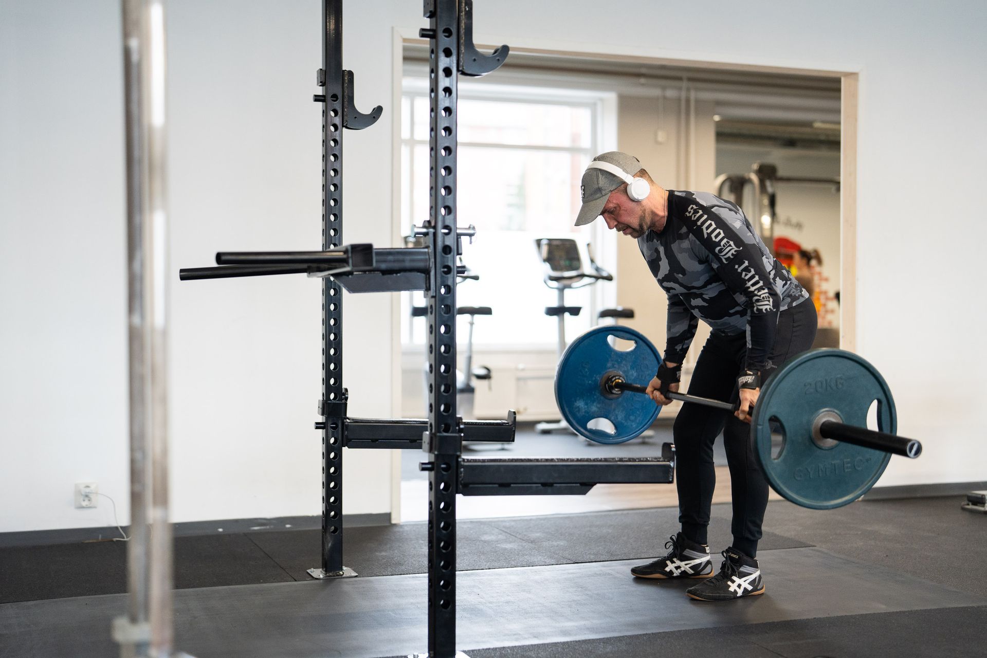 Mies nostaa tankoa kuntosalilla