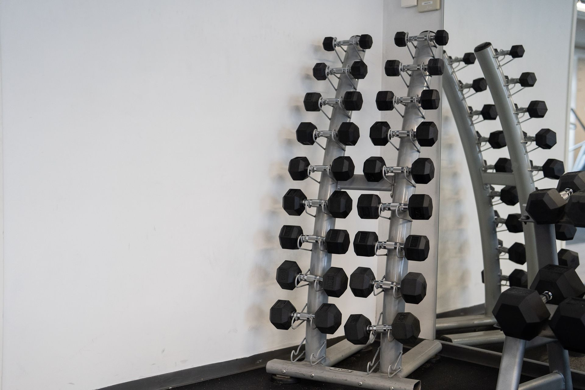 Rivi käsipainotelineitä kuntosalilla