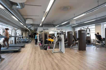 Nainen juoksee juoksumatolla kuntosalilla