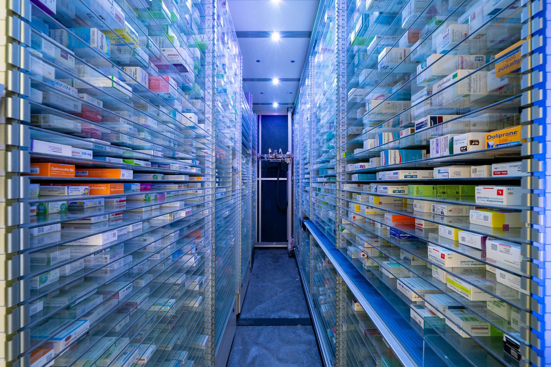 Stockage de plusieurs médicaments dans des armoires sous une lumière bleue.