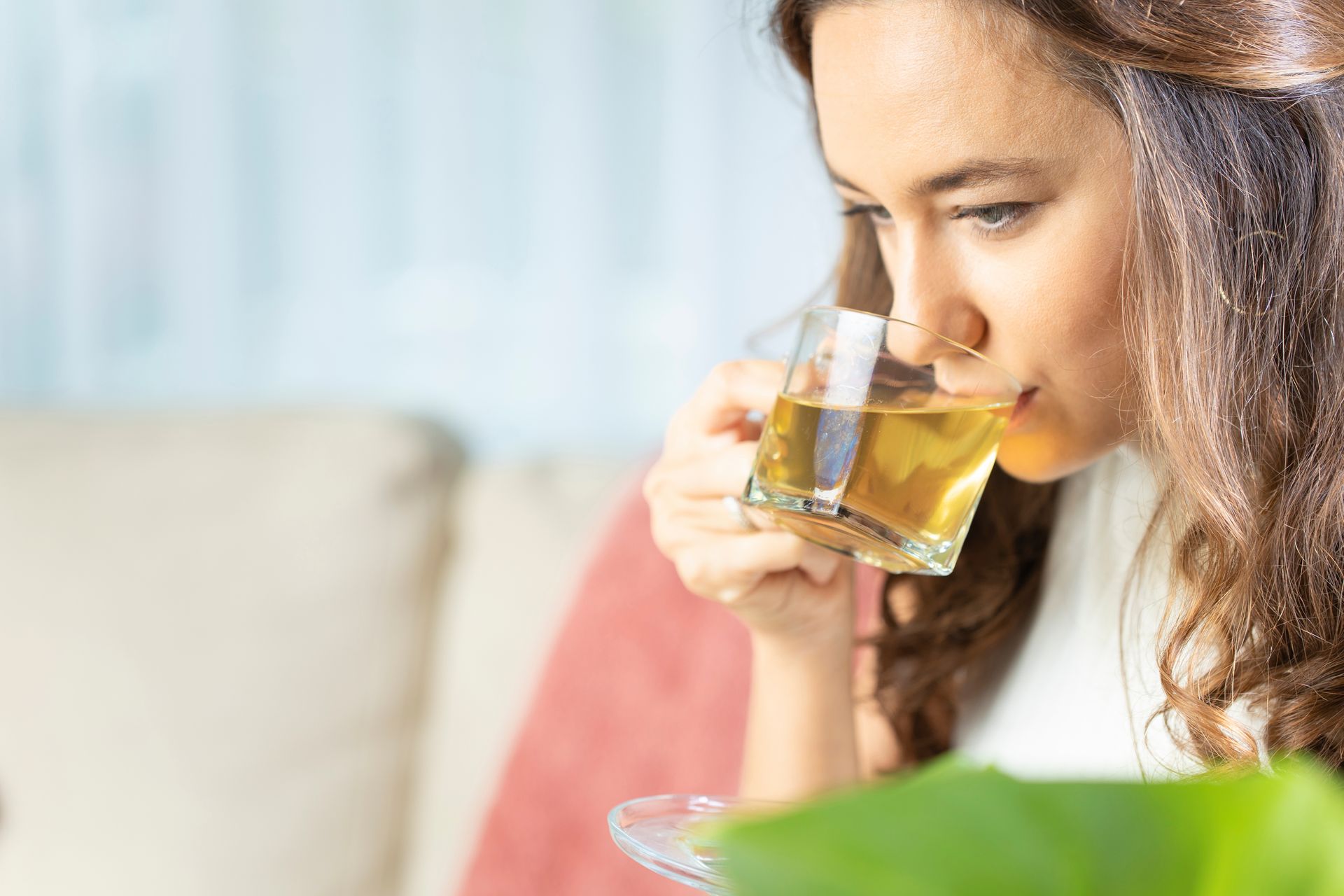 Une femme en train de boire une tasse de tisane.