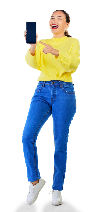 Une personne souriante, vêtue d'un pull et d'un jean, brandit et désigne un écran de smartphone.