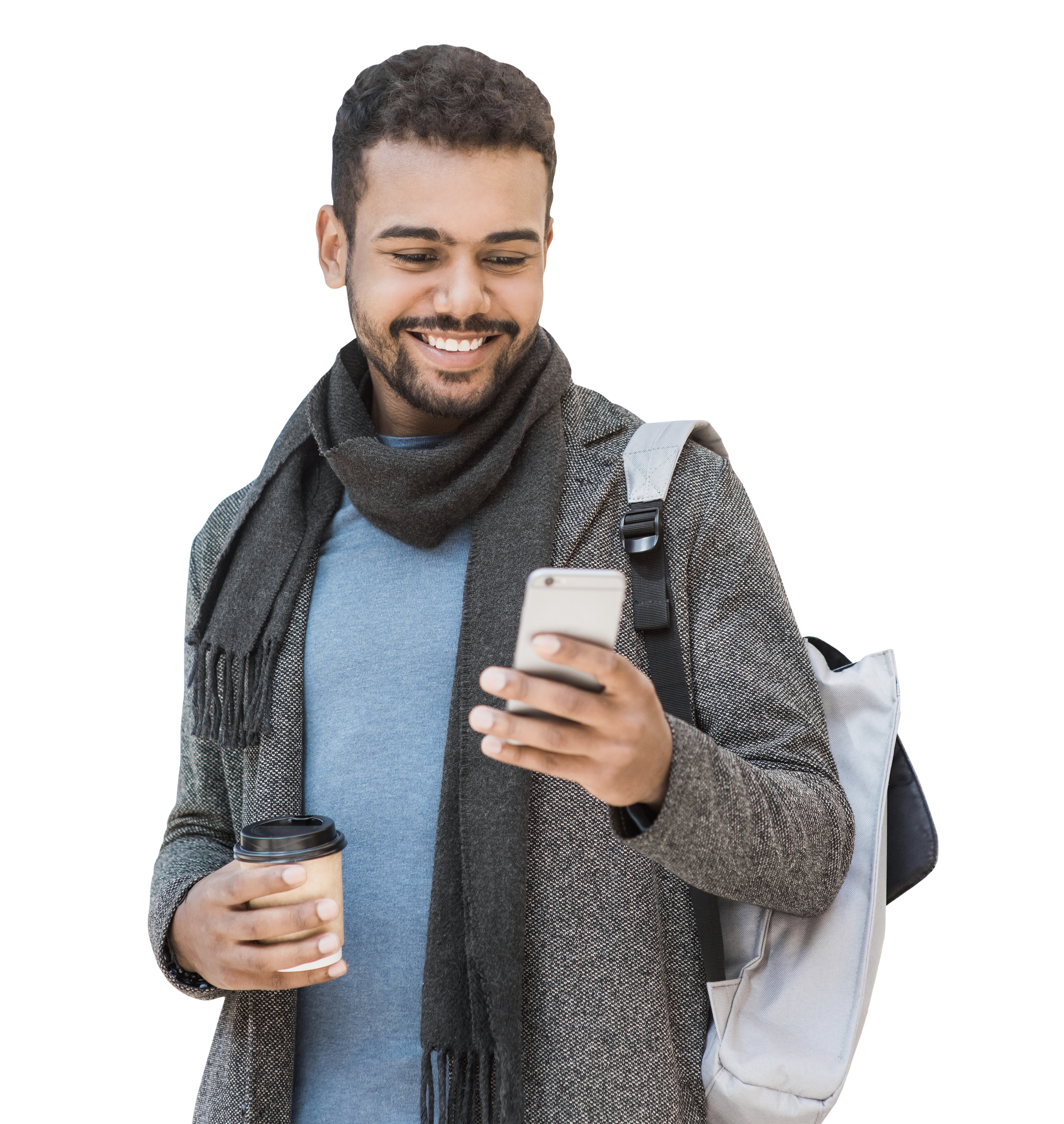Une personne souriante, vêtue d'un manteau et d'une écharpe, tient une tasse de café et regarde son smartphone, avec un sac à dos sur une épaule.
