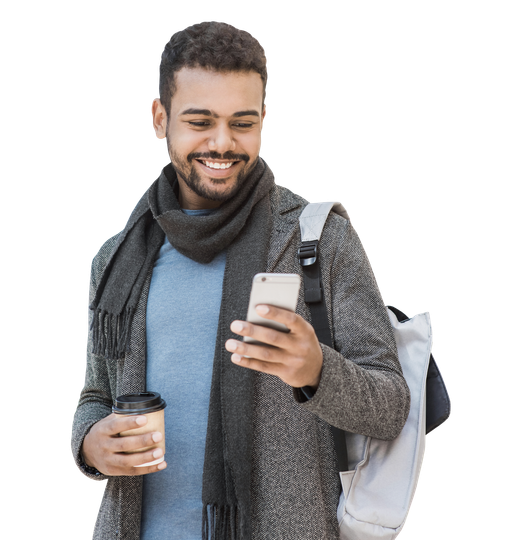 Une personne souriante, vêtue d'un manteau et d'une écharpe, tenant une tasse de café et regardant un smartphone.