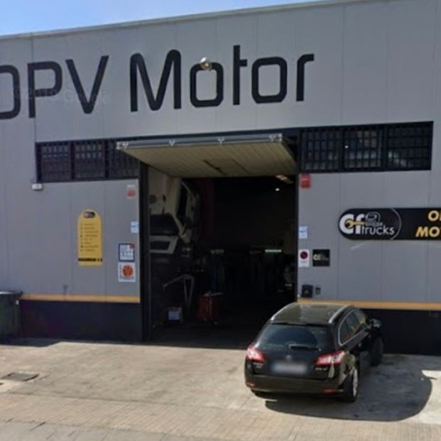 Un coche está aparcado delante de un edificio que dice DPV Motor.