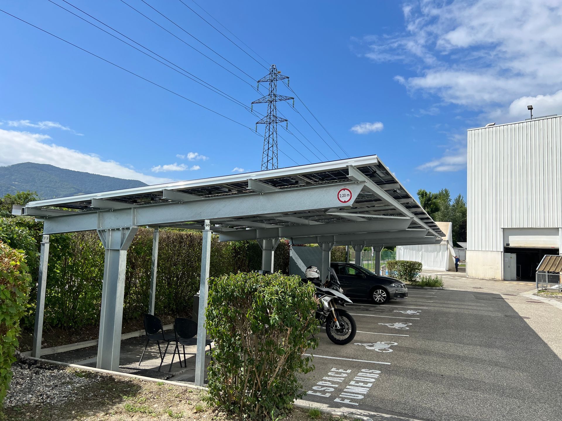 Carport métallique avec des voiture garées