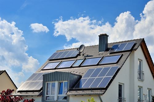 Ein Haus mit vielen Sonnenkollektoren auf dem Dach