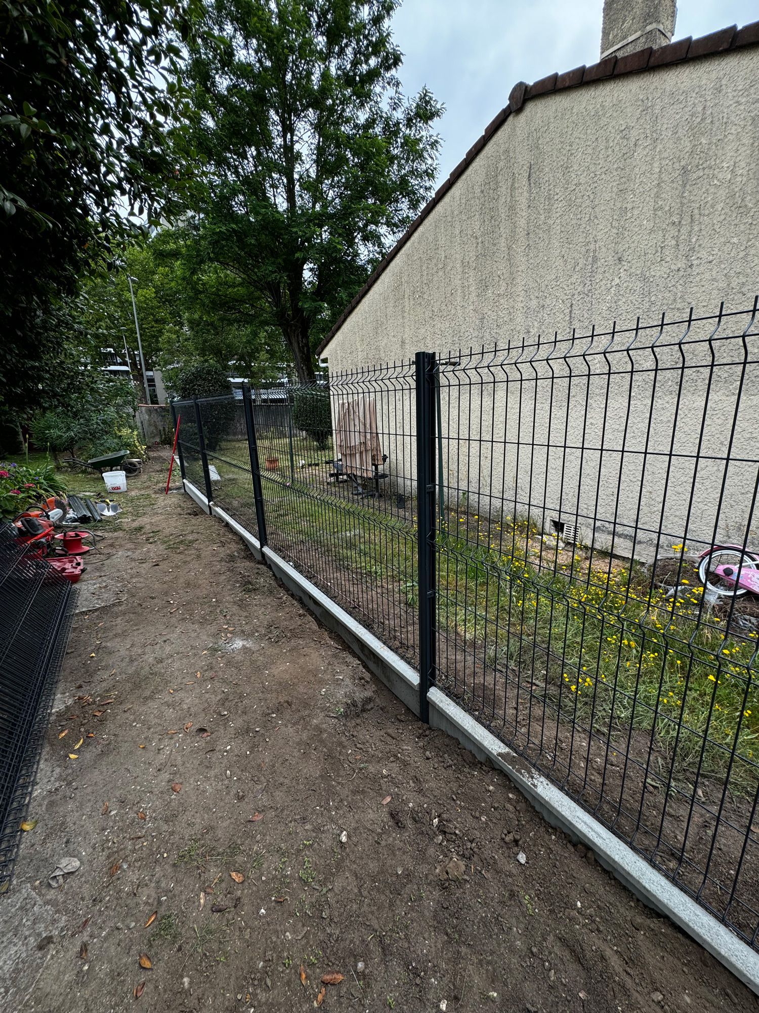 Une clôture de séparation devant une maison.