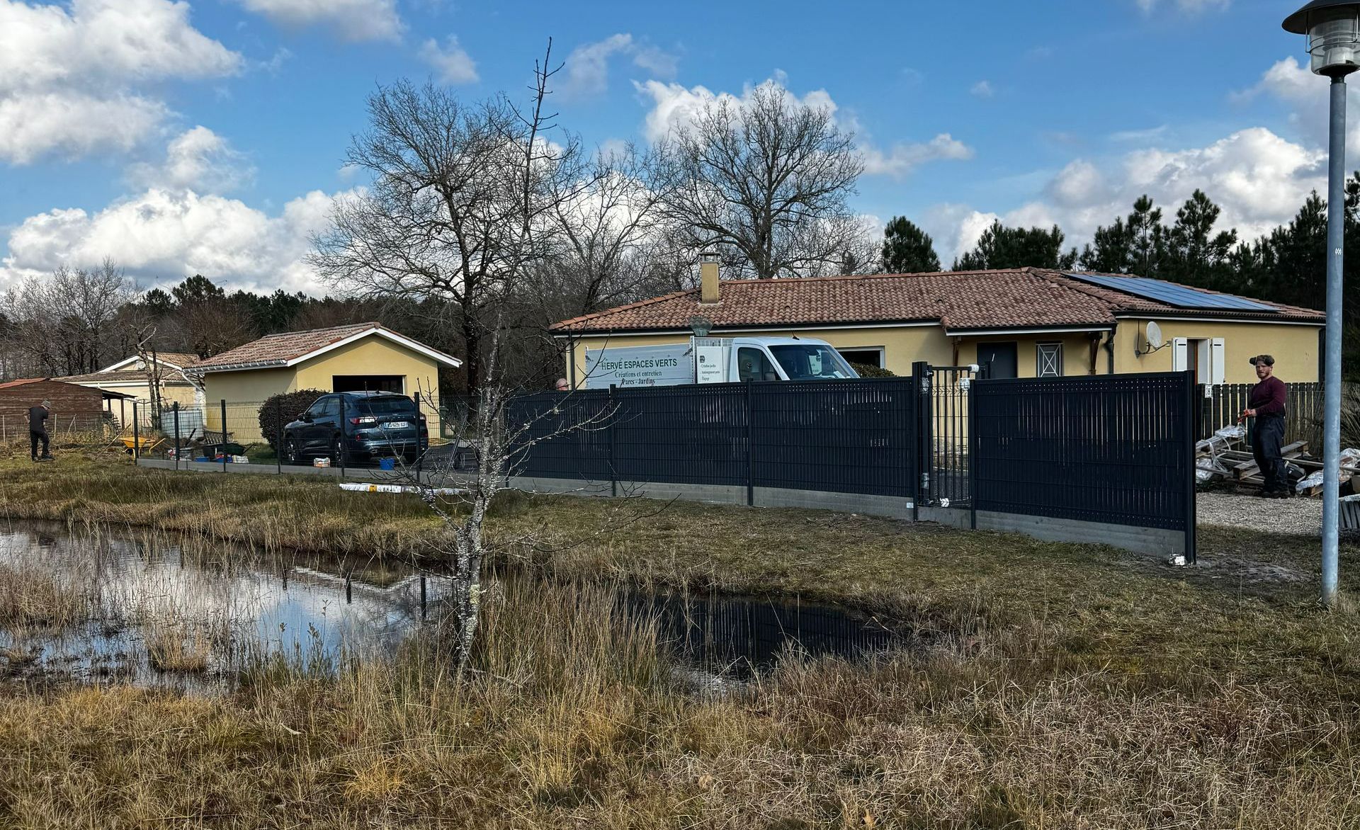 Une clôture derrière un étang.