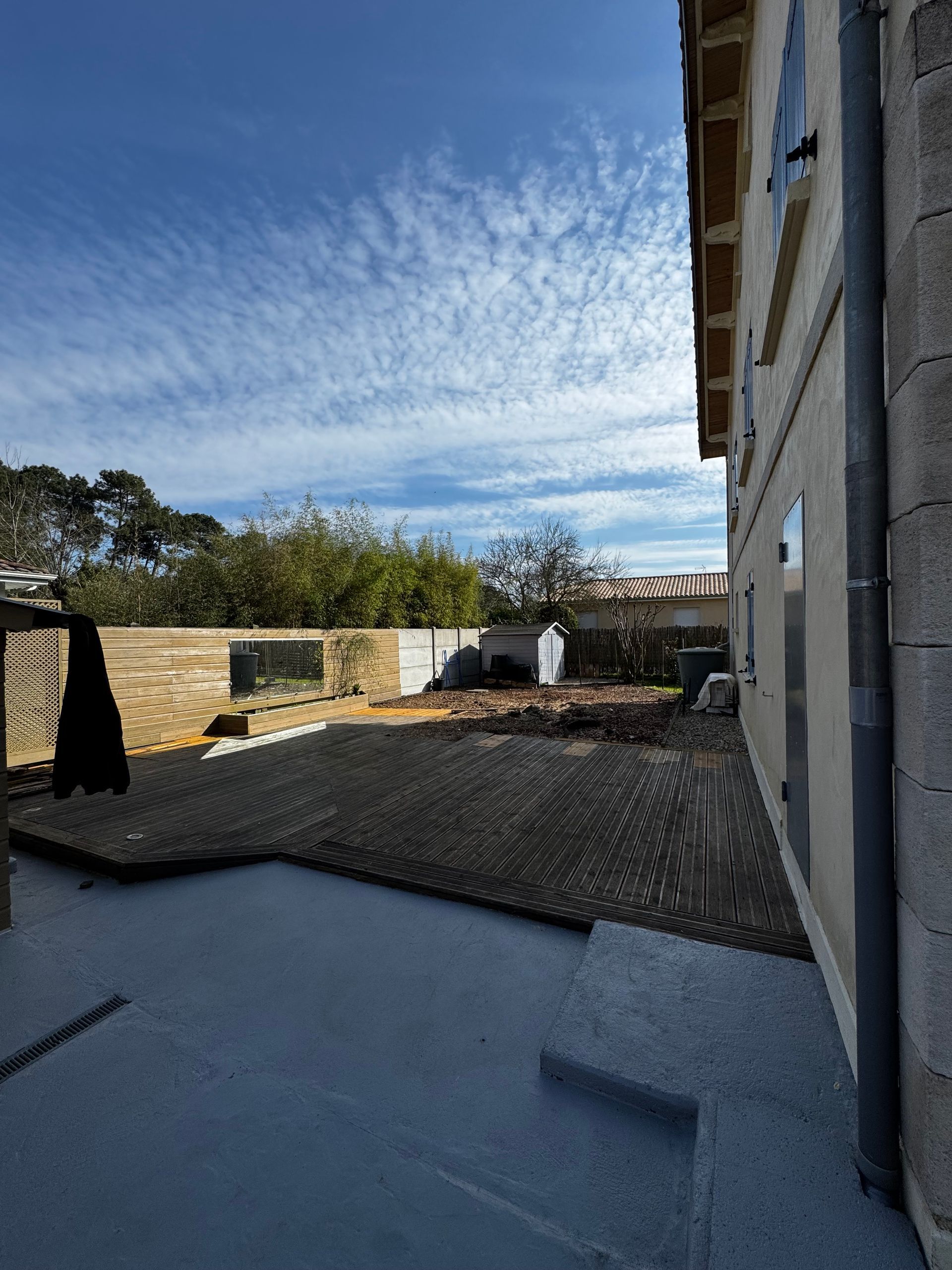 L'arbre n'est plus présent derrière la terrasse en bois.