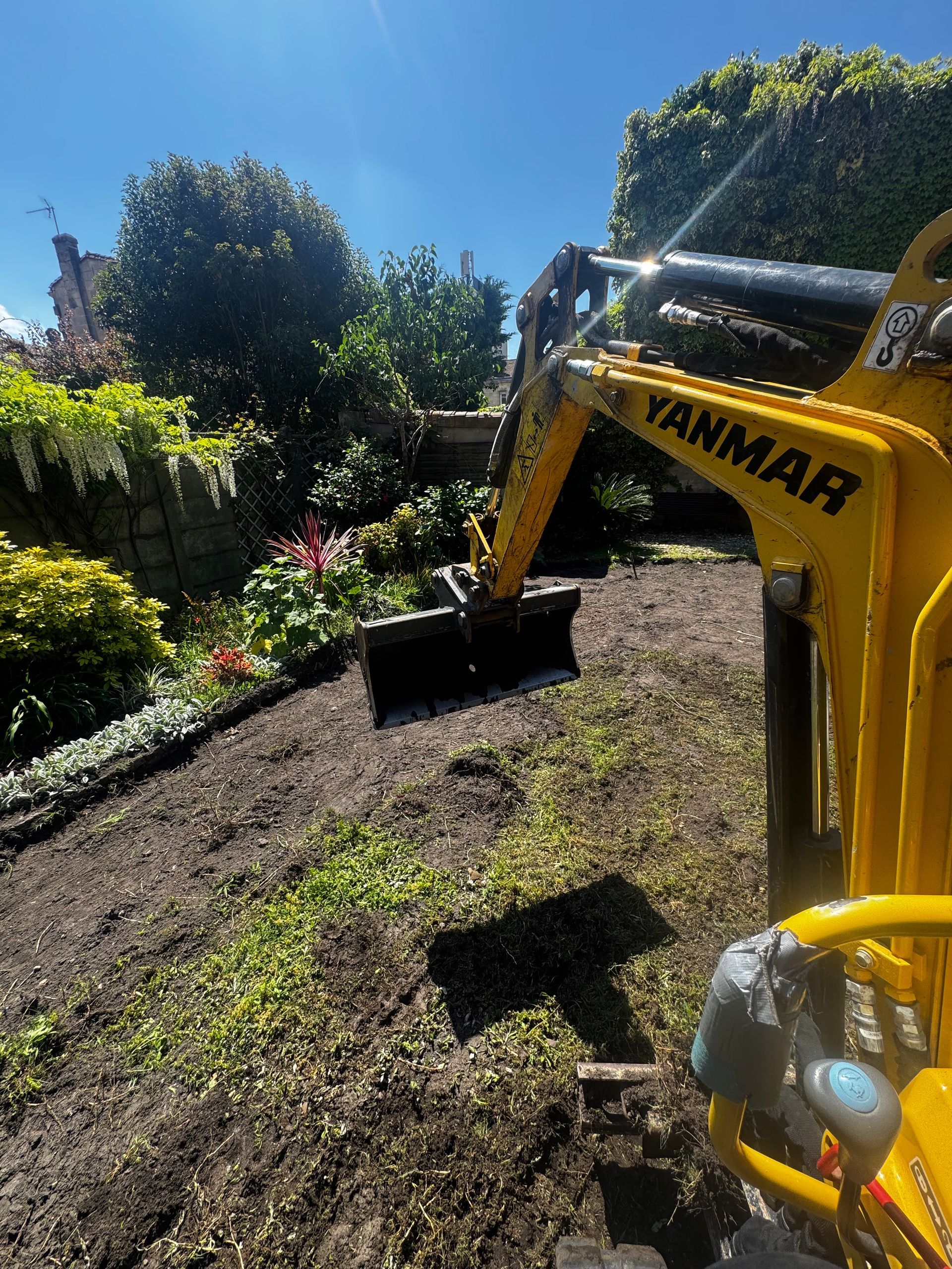 Pelleteuse jaune dans un jardin.