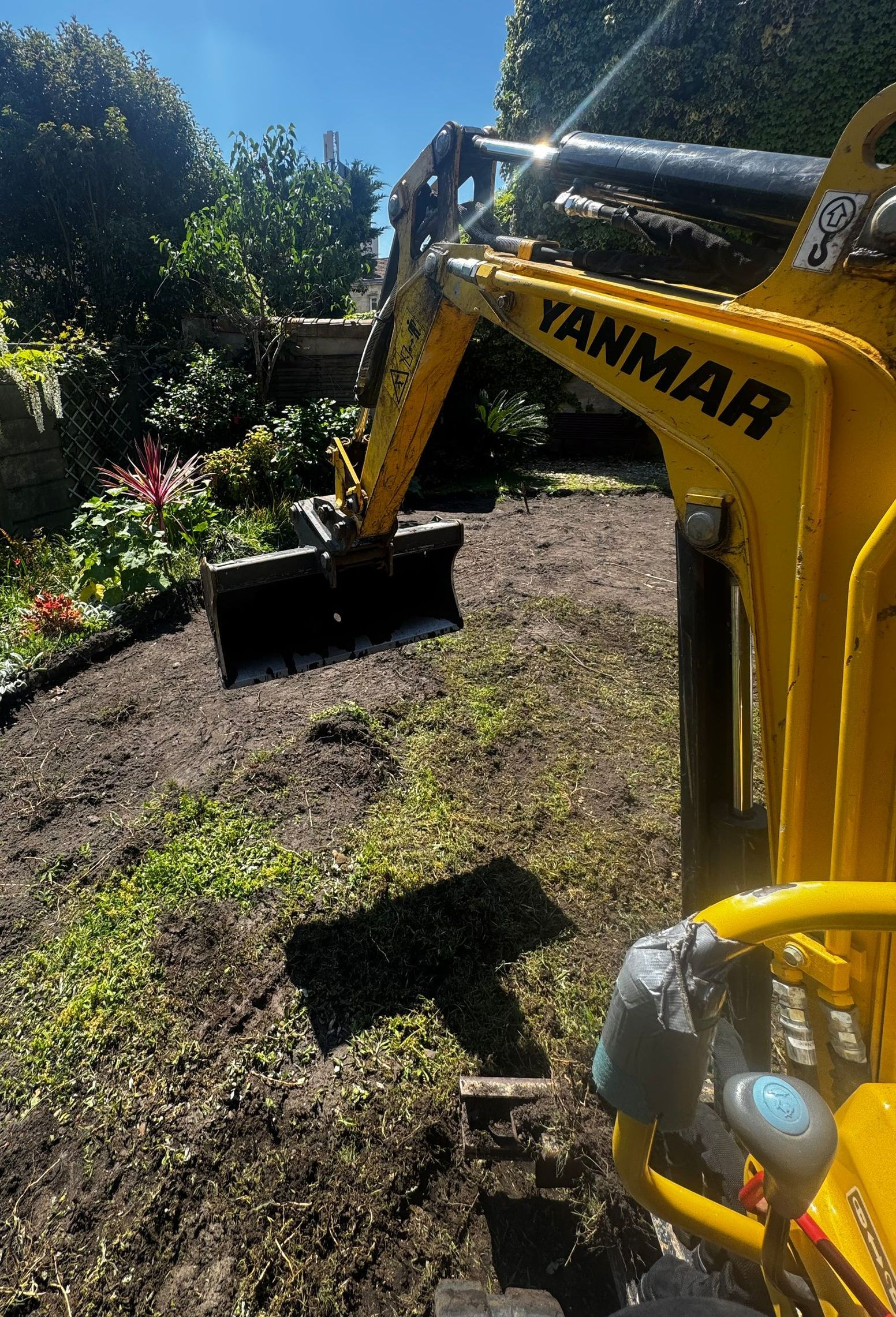 Minipelle travaillant sur un jardin.