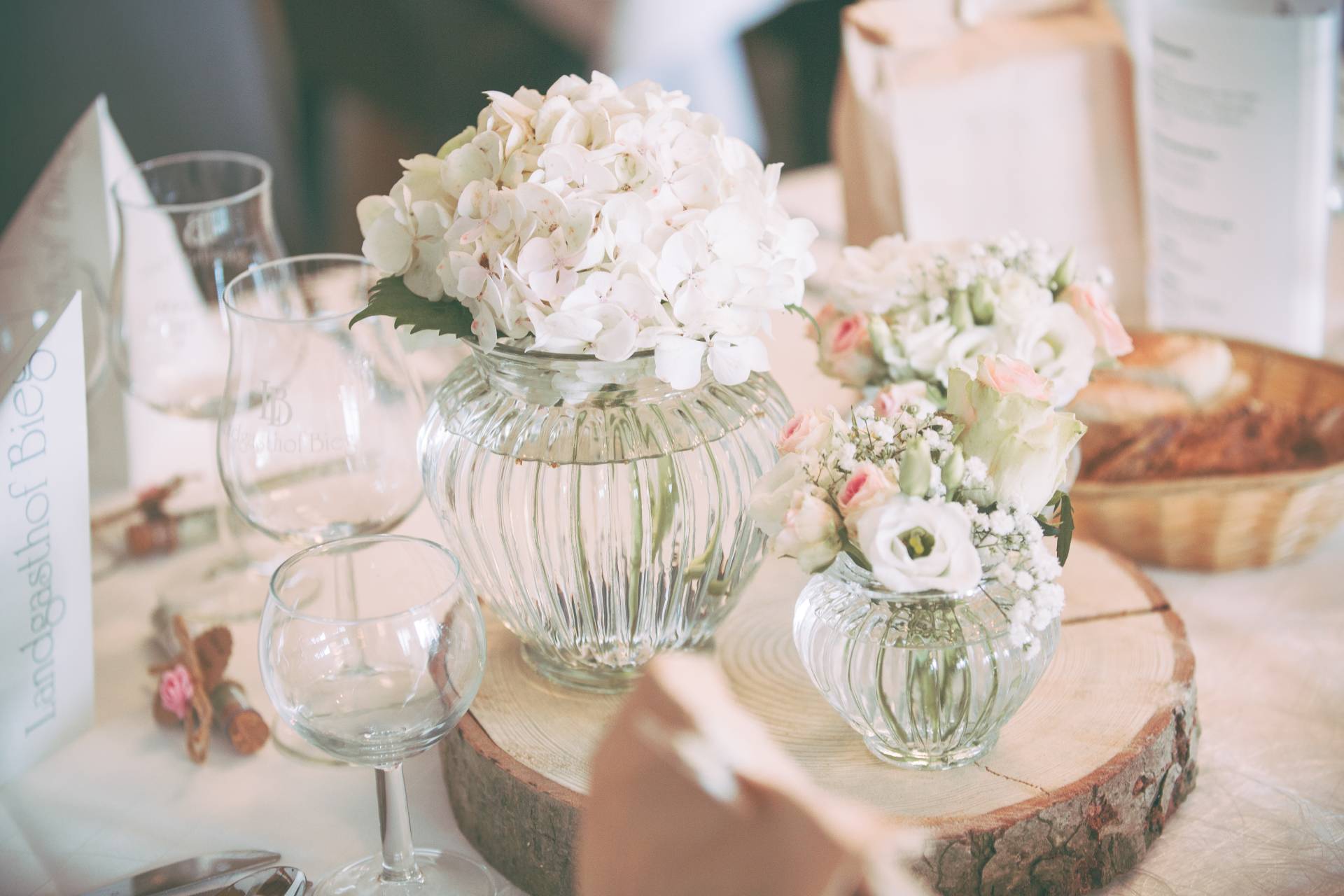 Weiße Blumendeko auf einem Baumstamm auf dem Tisch