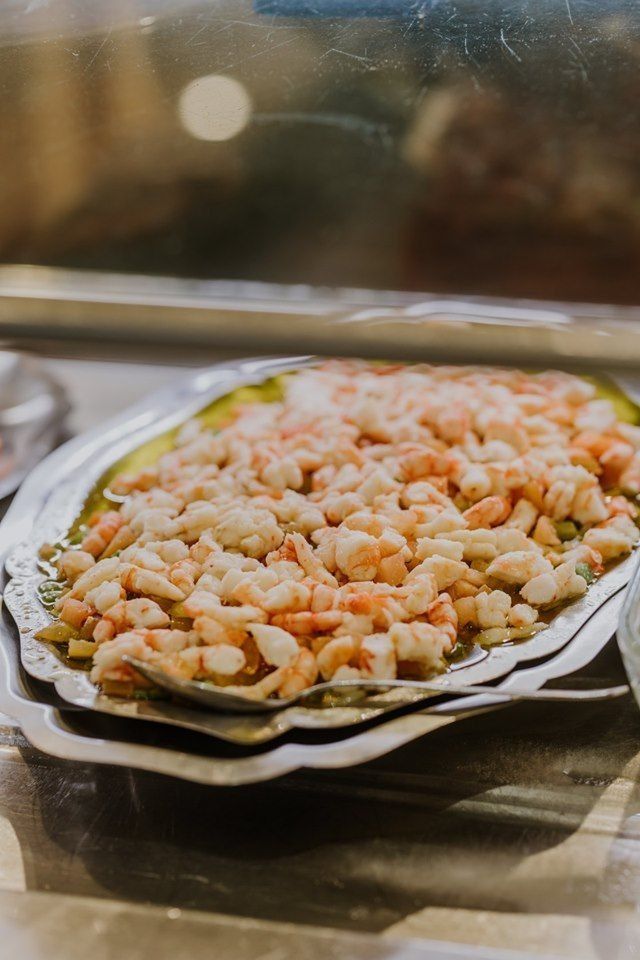 Un primer plano de un plato de camarones y verduras en una mesa.