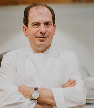 Un chef con los brazos cruzados y un reloj.