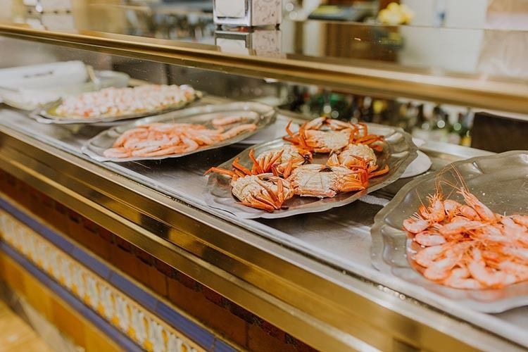 Una vitrina llena de platos de camarones y cangrejos.