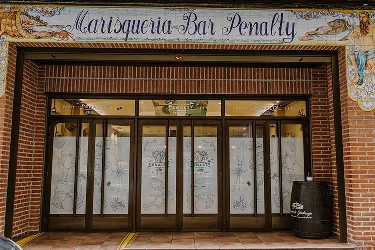 Un edificio de ladrillo con un cartel que dice 'marisquia bar penalty'