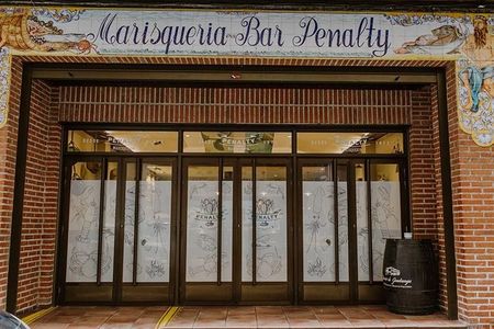 Un edificio de ladrillo con un cartel que dice 'marisquia bar penalty'