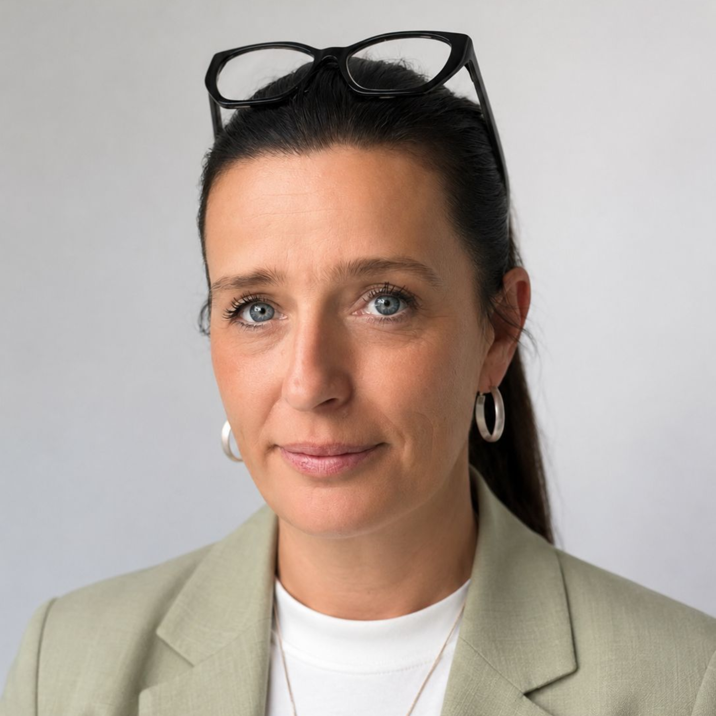 Bild von Nicole Wricke mit Brille auf dem Kopf, weißem Hemd und hellbeigem Blazer