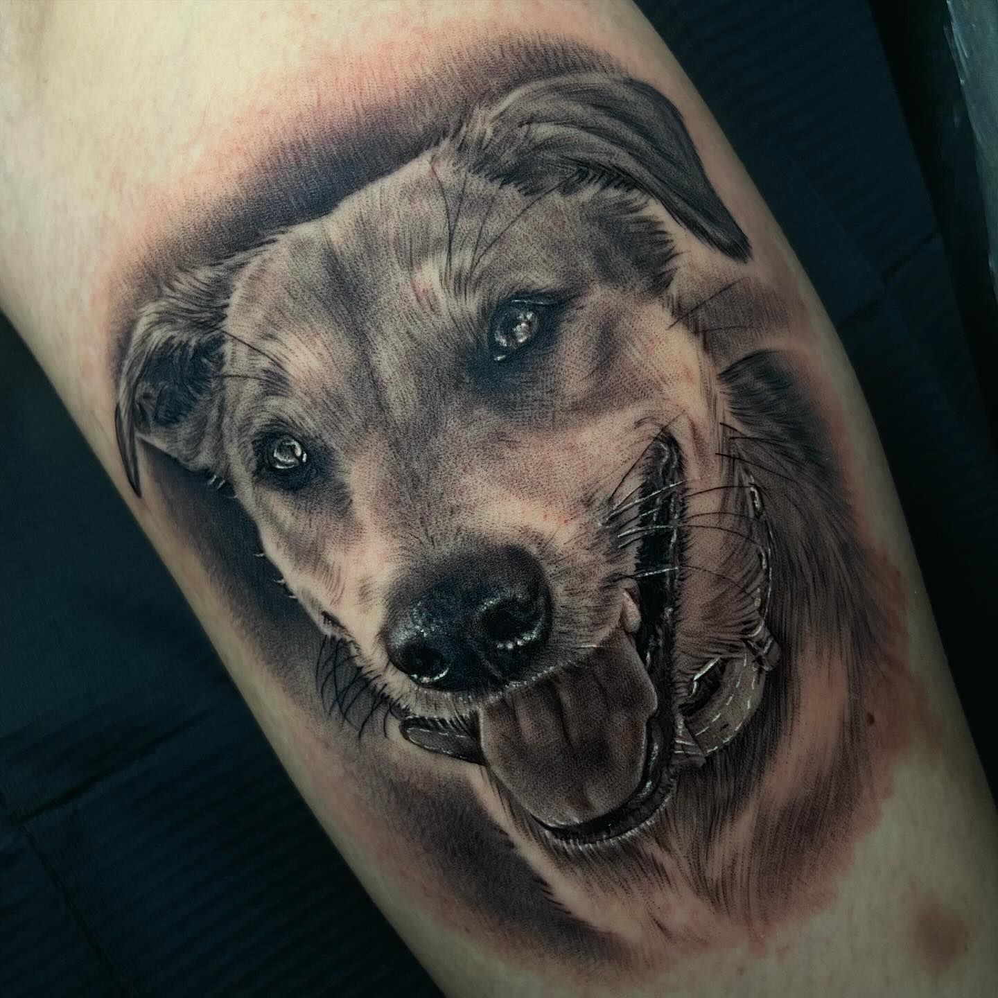 Un tatuaje de un perro con la lengua afuera.