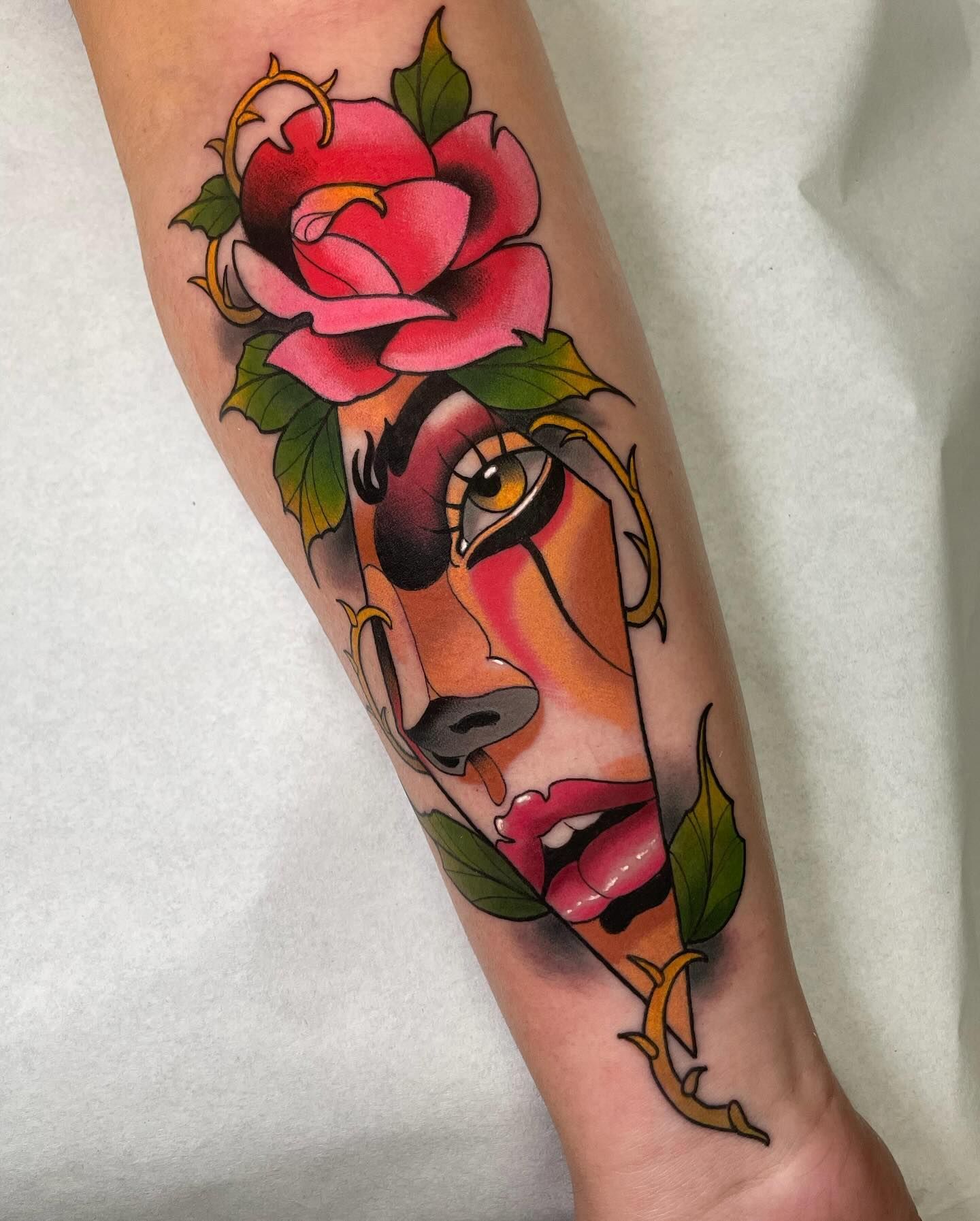 Un tatuaje de la cara de una mujer con una rosa rosada.