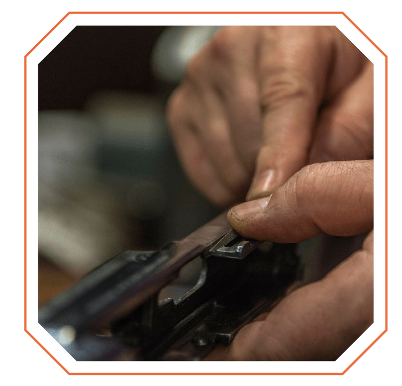 Mains travaillant une arme